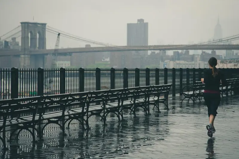 Course à pied sous la pluie le long d’un quai