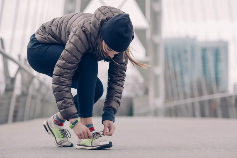 Femme qui lace ses baskets avant de courir