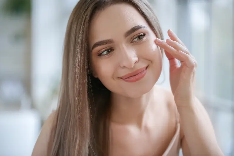 Femme qui applique une crème sur son visage