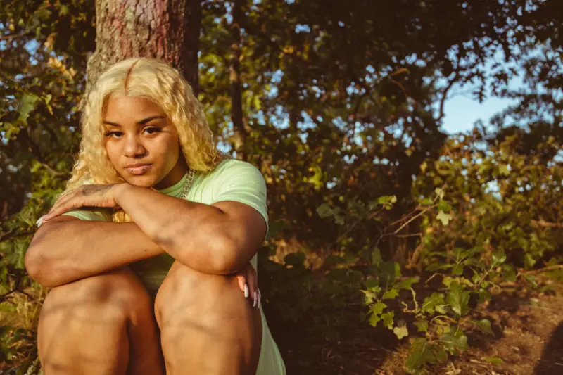 Jeune femme assise sous un arbre