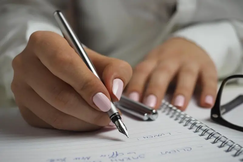 Main qui écrit avec un stylo plume