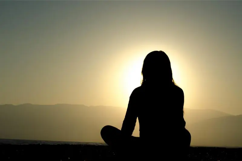 Silhouette en méditation au coucher du soleil