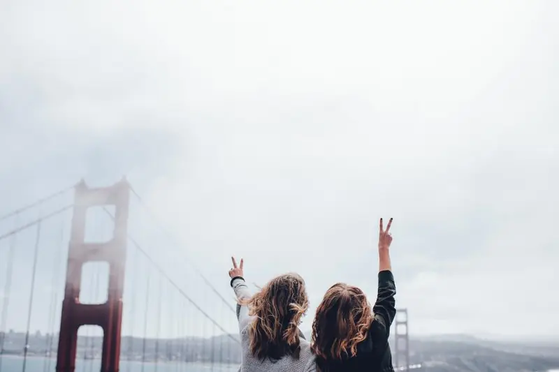 Deux amies bras levés face au Golden Gate