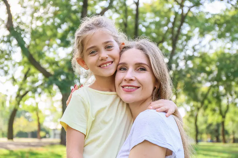 Mère et fille enlacées dans un parc