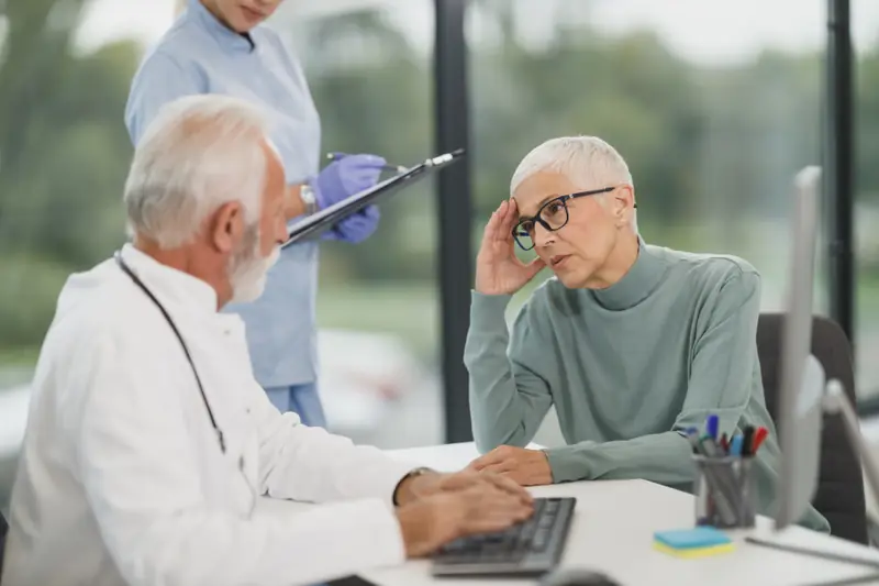 Femme aux cheveux gris en consultation chez son médecin