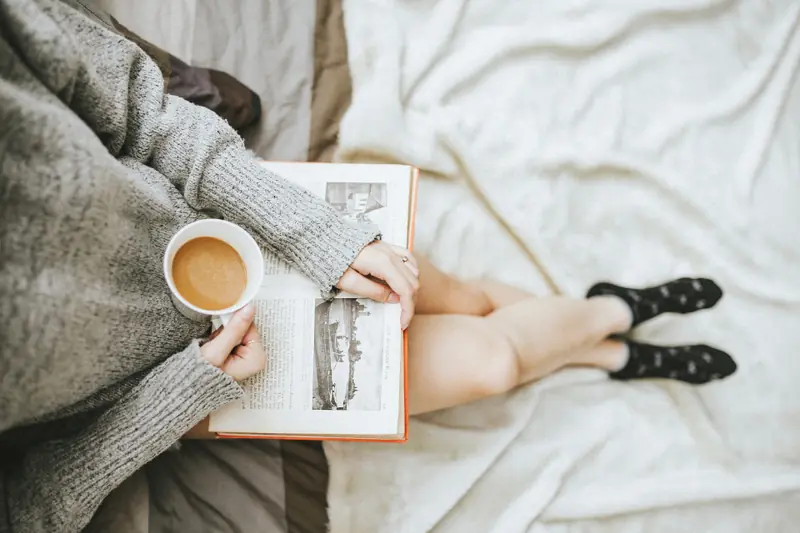 Lecture au lit avec une tasse de café