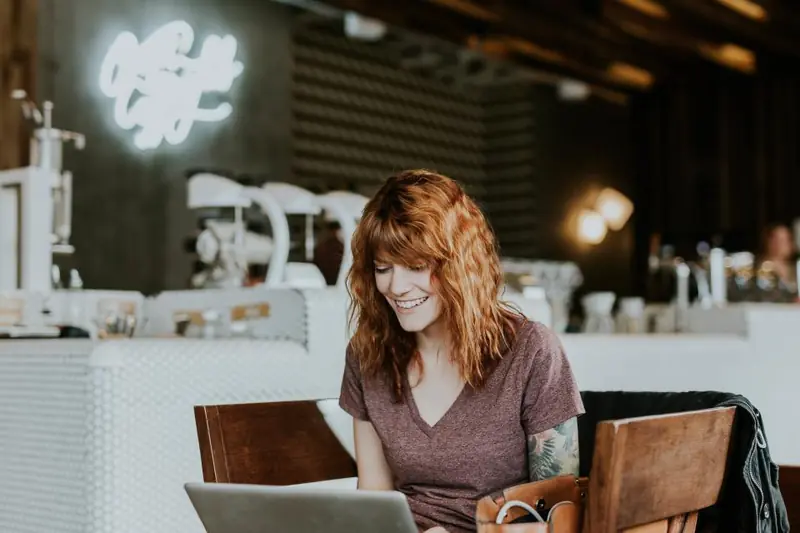 Femme sur son ordinateur dans un café